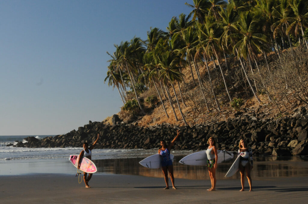 Turistas practicando surf en la playa El Cuco.